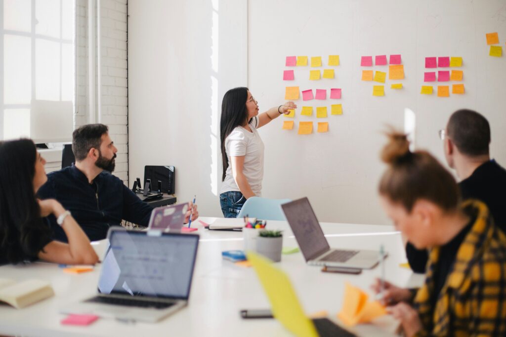 board room of people, one person at front looking at white board